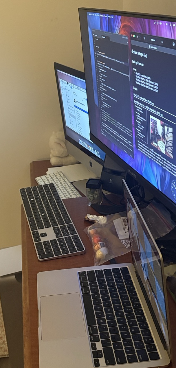 Long shot of three computer screens in a row. Front to back: MacBook Air, great big external display for the MacBook Air with some windows editing this very page, and on a small, lower-down dresser, the venerable iMac. Each display's corresponding keyboard - the internal one on the MacBook Air, a Magic Keyboard with black keys and number pad, and a very old classic Apple keyboard, like would've come with the iMac.